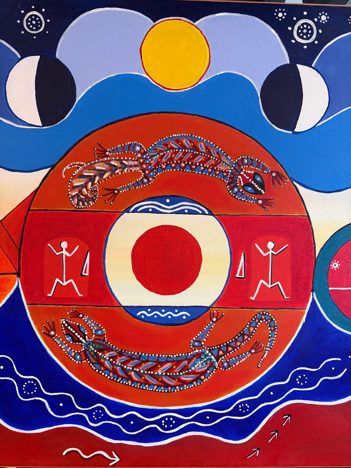 Central painting detail showing two patterned animal forms around a red circle, with sun and moon shapes above.