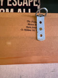 Reverse detail of the clown picture showing a metal hanging bracket and picture-framer stamp.