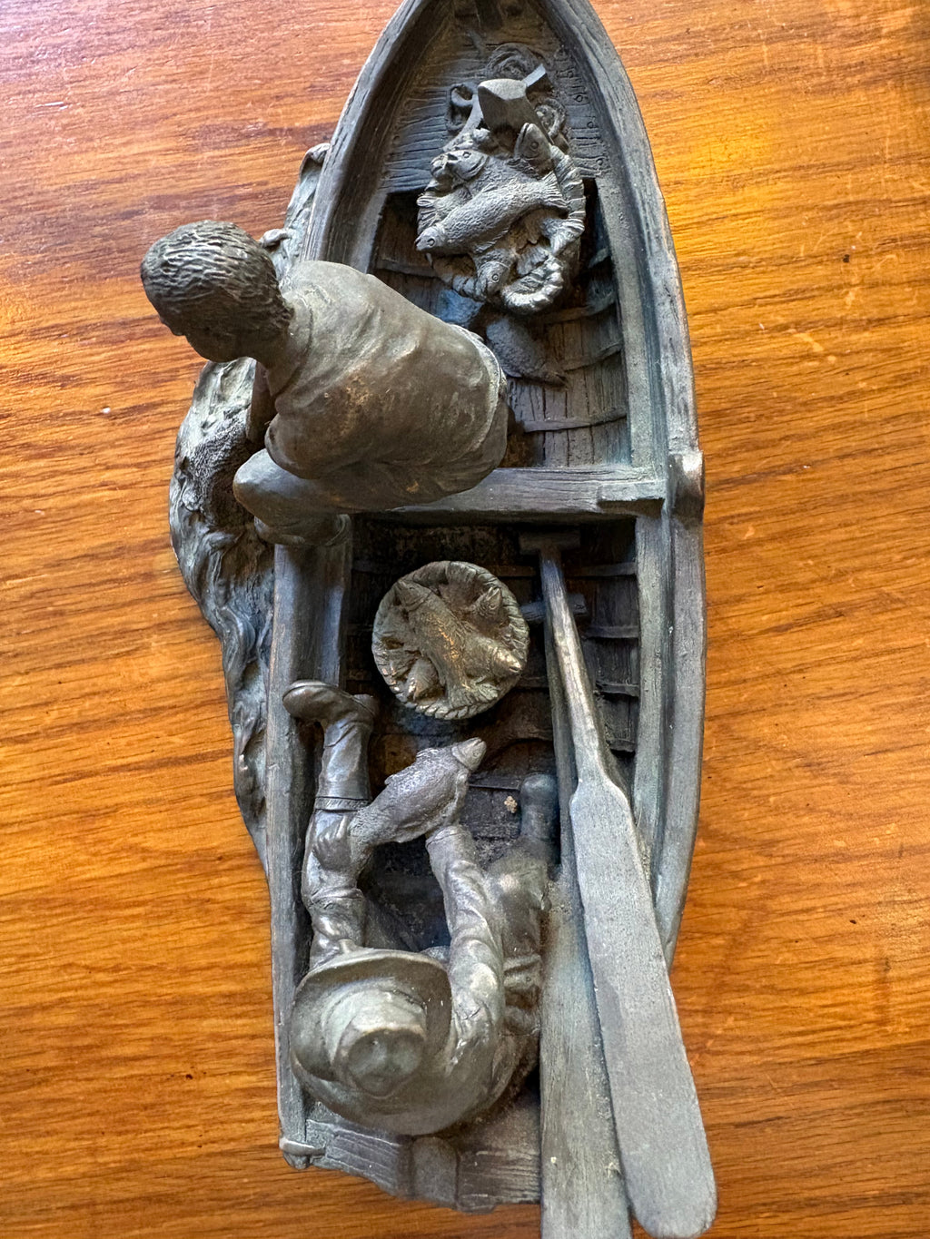 Overhead view of the fishing boat sculpture showing two fishermen, oars, baskets and fish