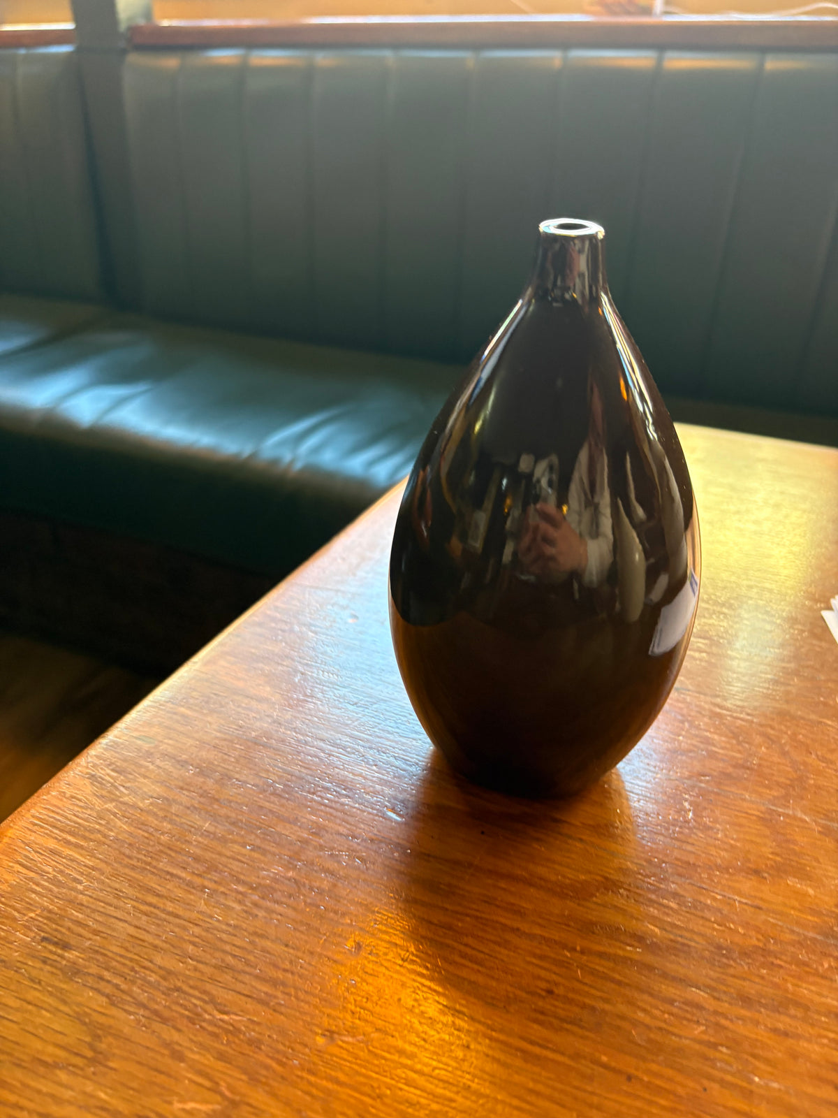 Dark brown glossy ceramic bud vase with teardrop body and narrow neck