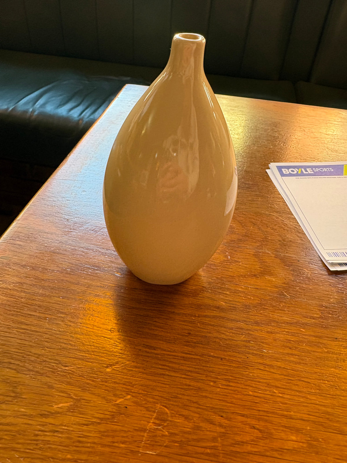 Cream teardrop ceramic bud vase with glossy finish and small round opening