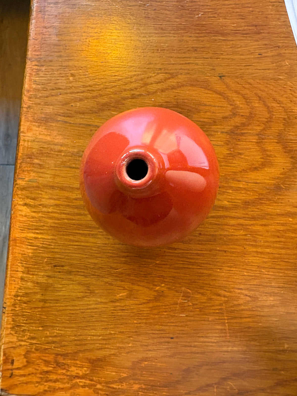 Top view of red ceramic bud vase showing its small circular opening