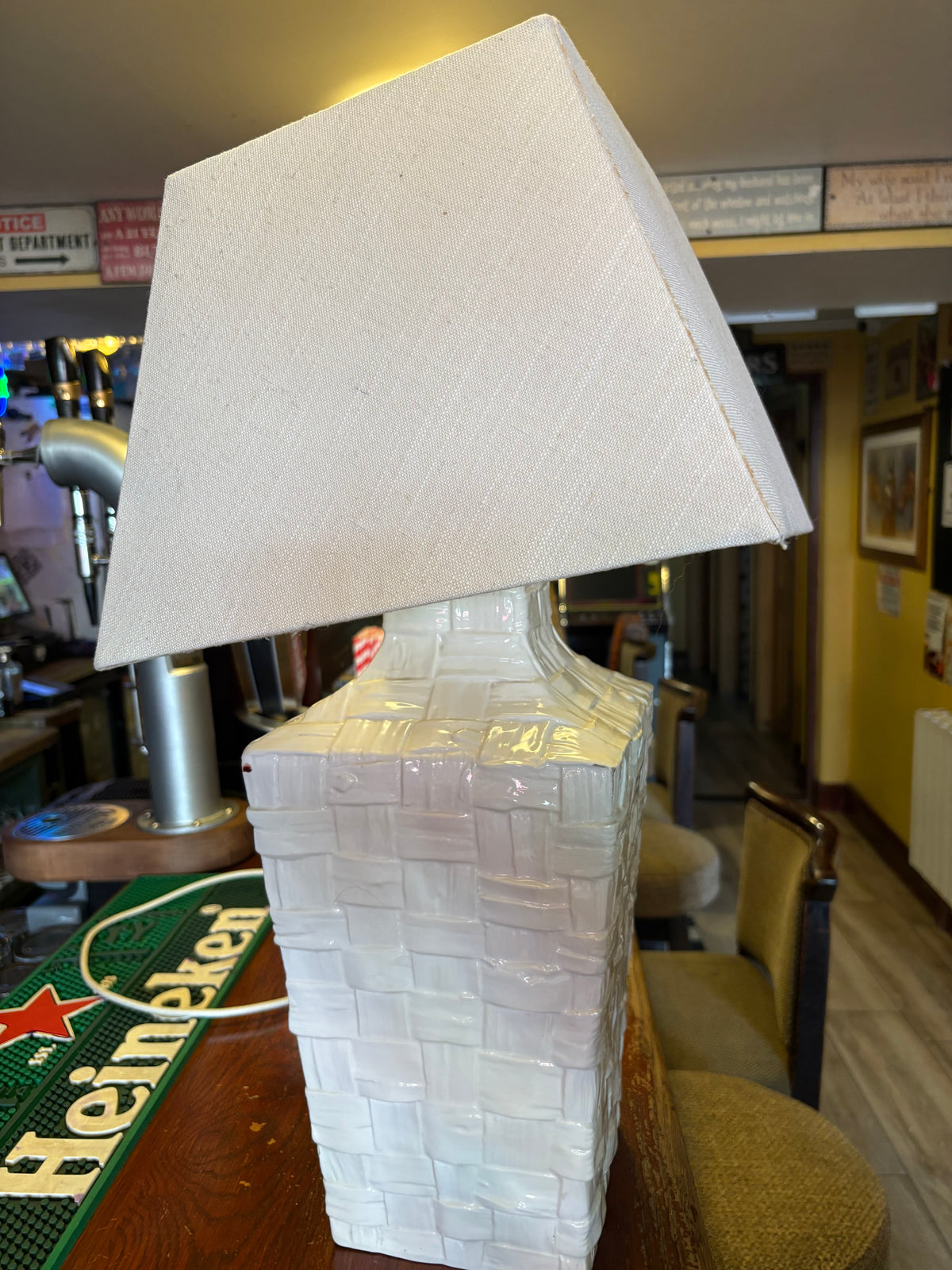 Angled view of white basket-weave ceramic lamp showing the textured body and rectangular shade
