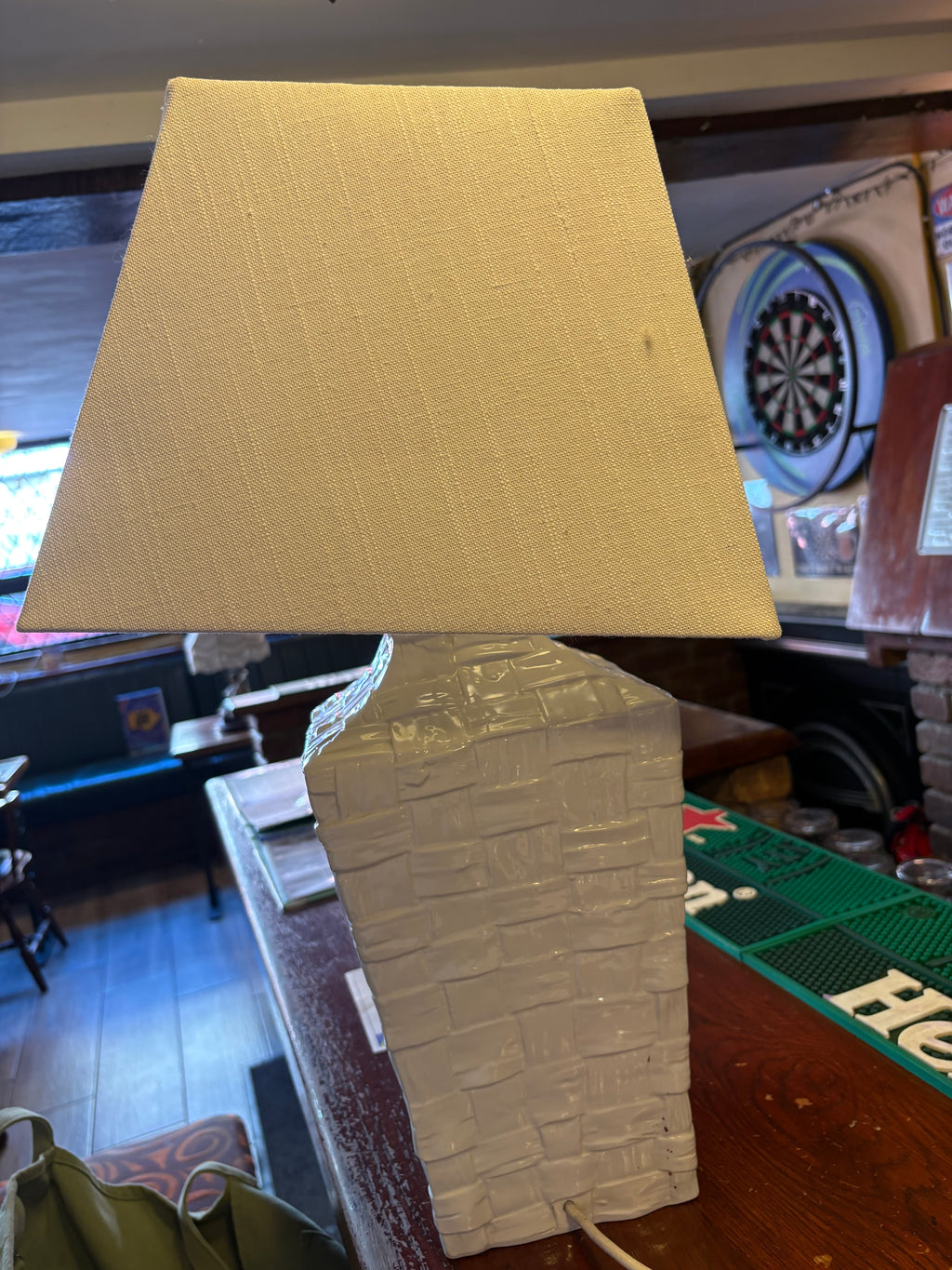 Rear view of white ceramic basket-weave lamp showing the cord emerging near the base