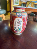 Red-ground porcelain vase with colourful floral borders and white panels depicting birds and flowers