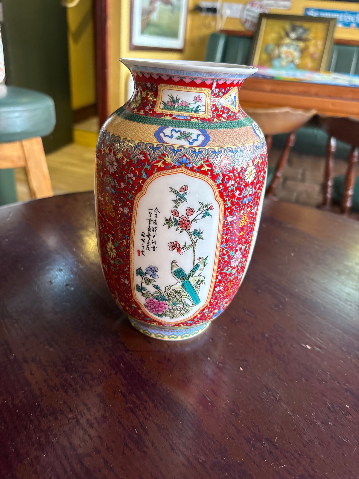 Red-ground porcelain vase with colourful floral borders and white panels depicting birds and flowers