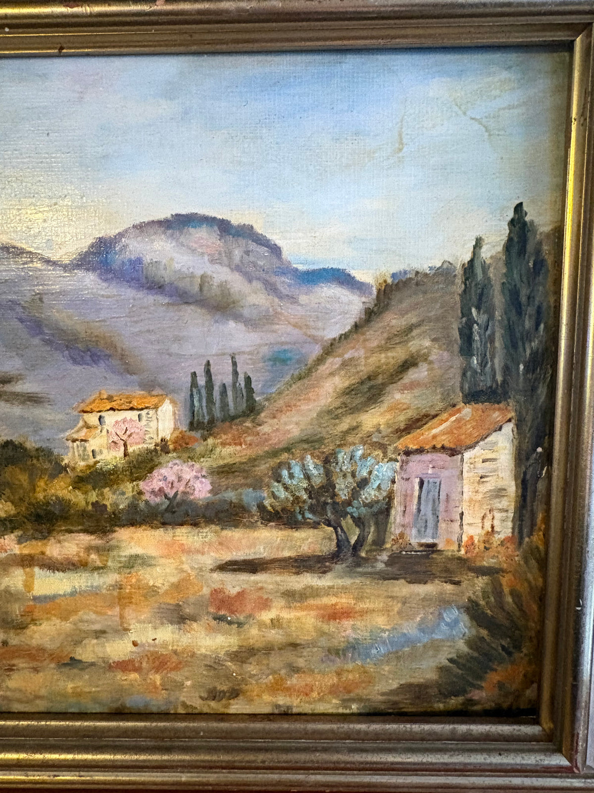 Right-side landscape detail showing a small outbuilding, tall dark trees and distant mountains.