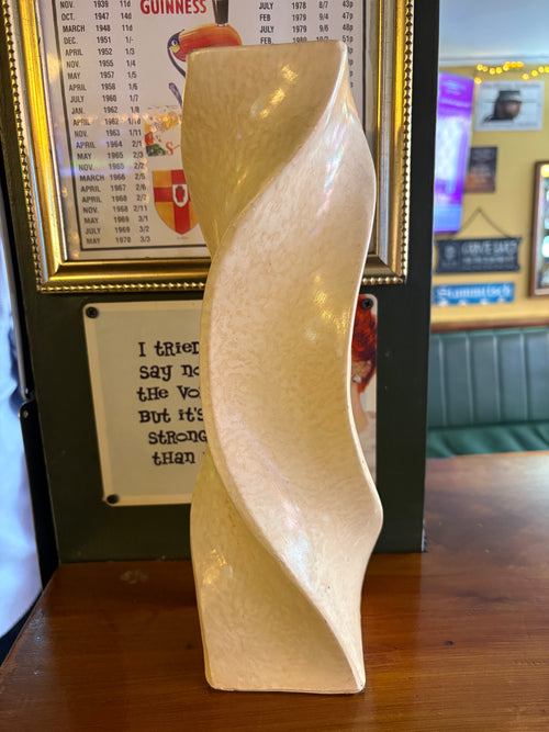 Rear view of cream twisted vase showing its curved sculptural form without the leaf motif