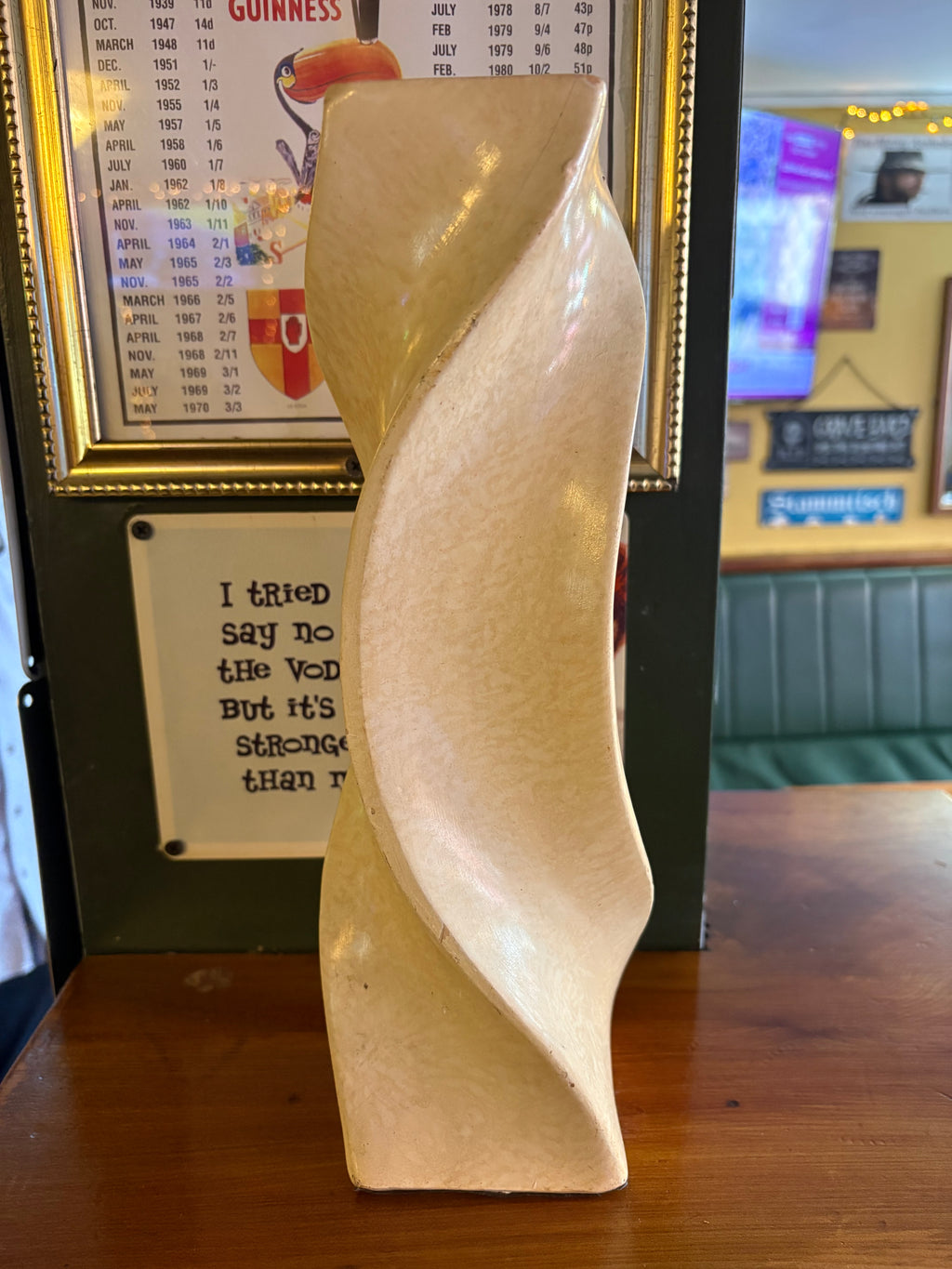 Angled rear view of cream vase showing the sweeping spiral edges and square base