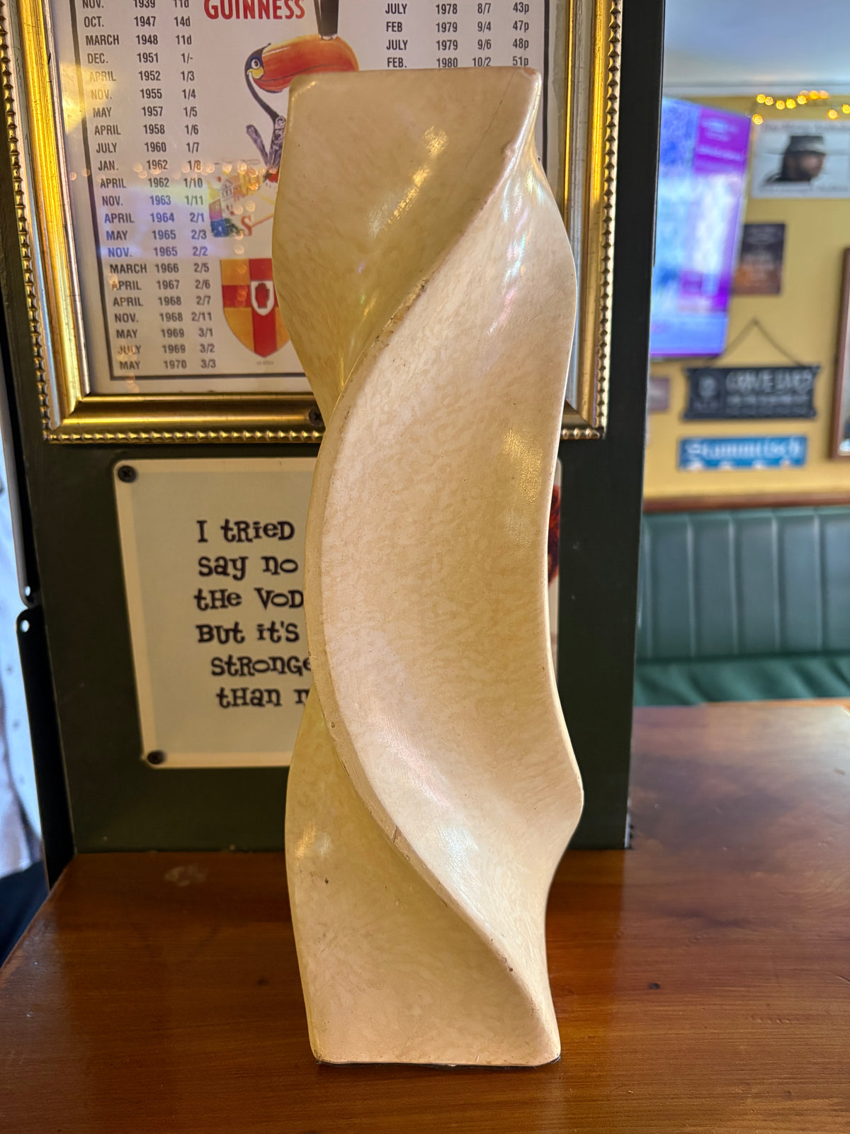 Angled rear view of cream vase showing the sweeping spiral edges and square base