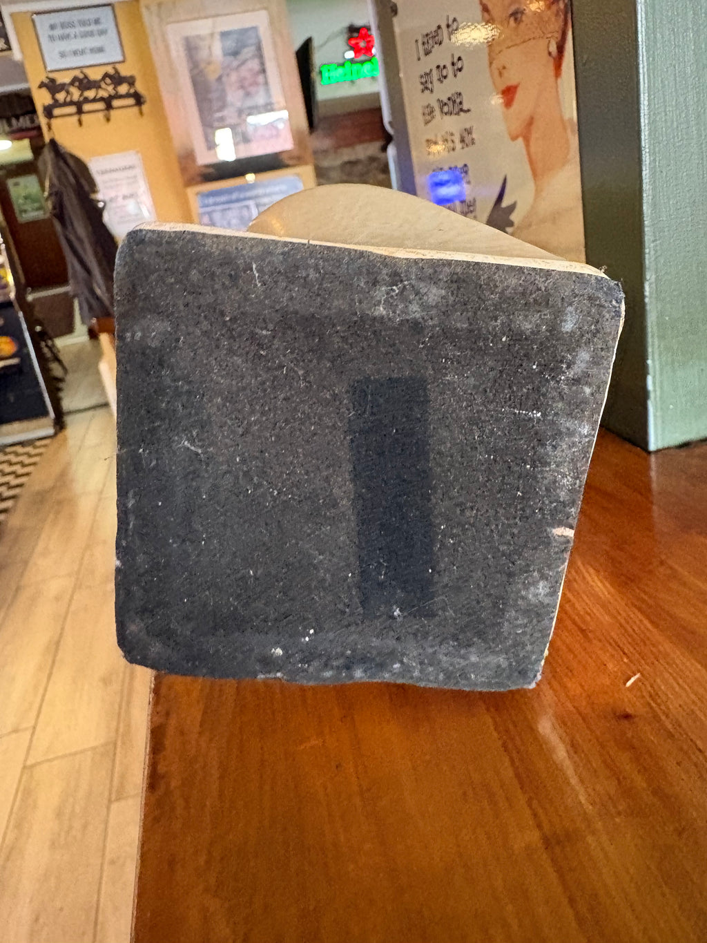Underside of cream twisted vase showing a dark square protective base covering