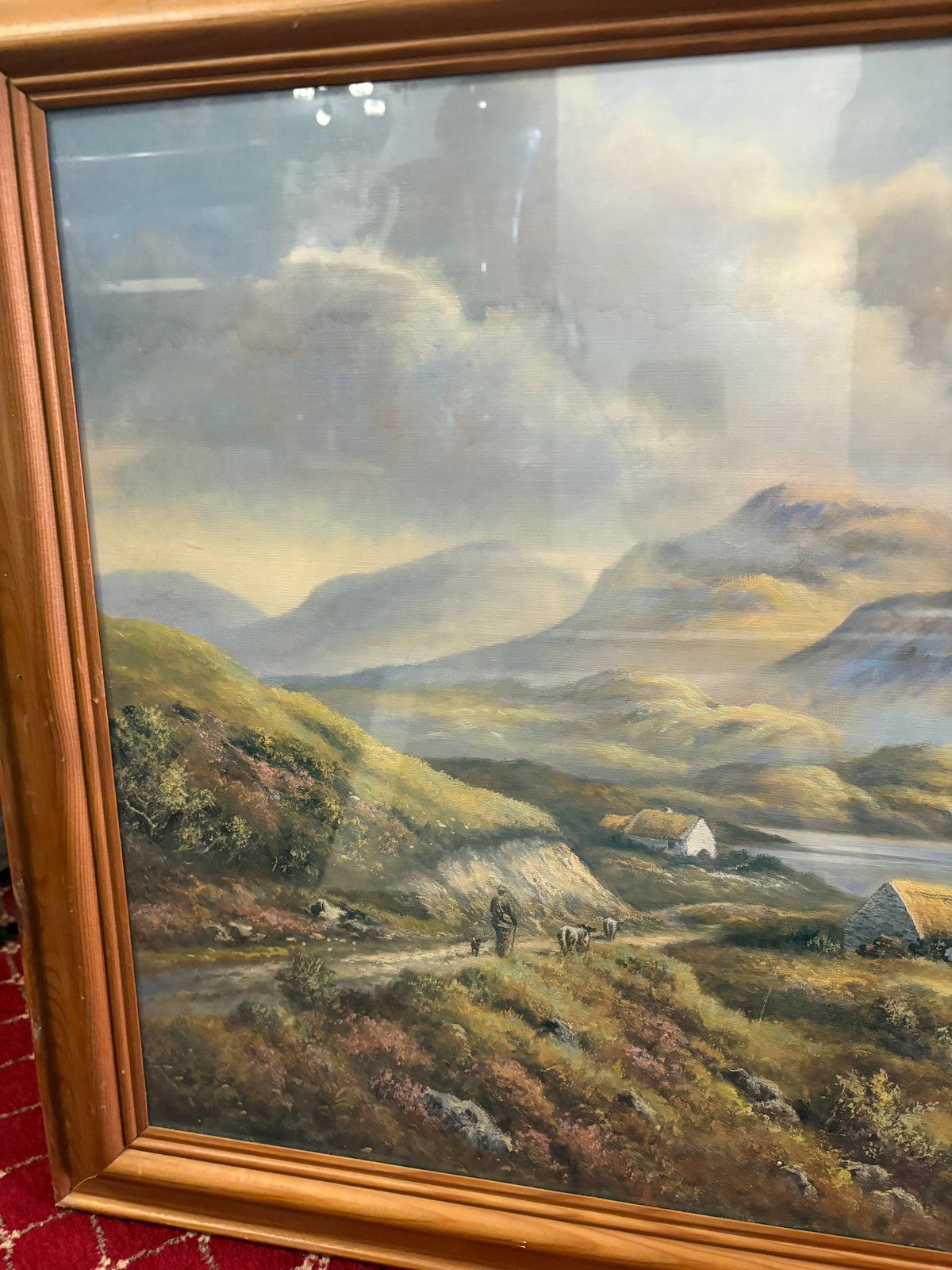 Left-side landscape detail showing a figure and animals on a path below rugged mountains.