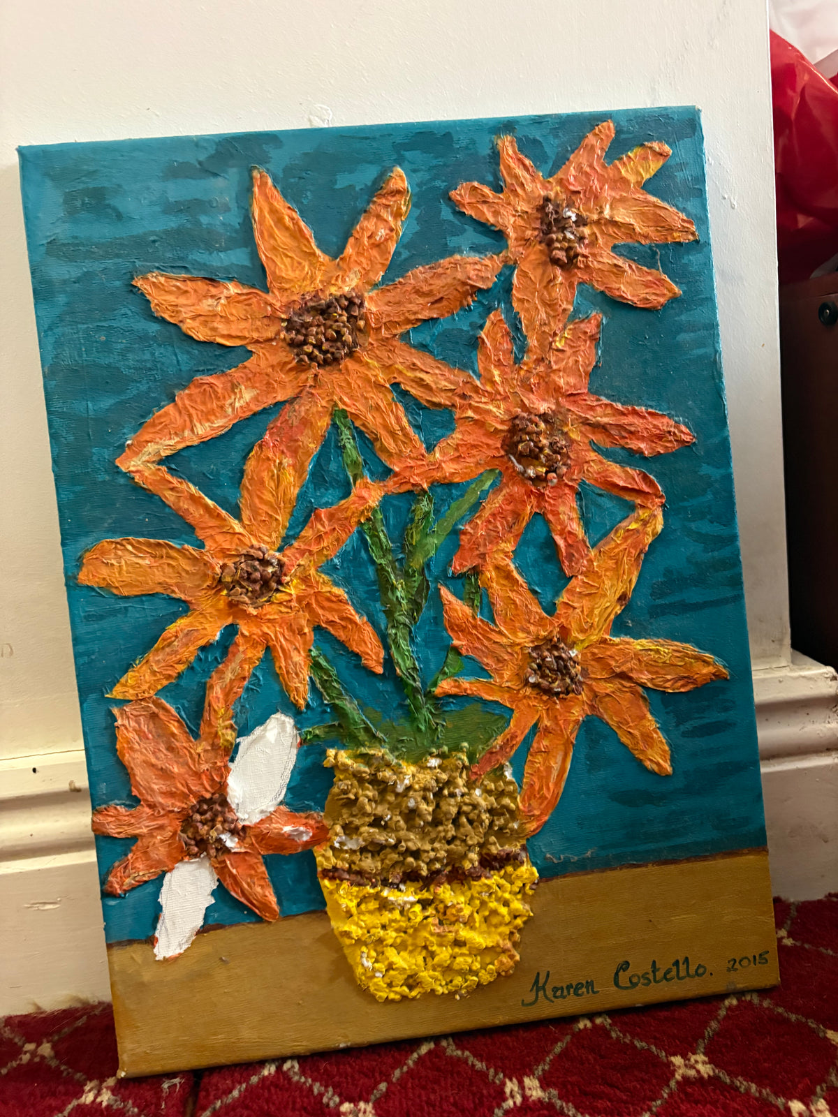Textured floral painting of orange flowers in a yellow and brown vase against a teal background.