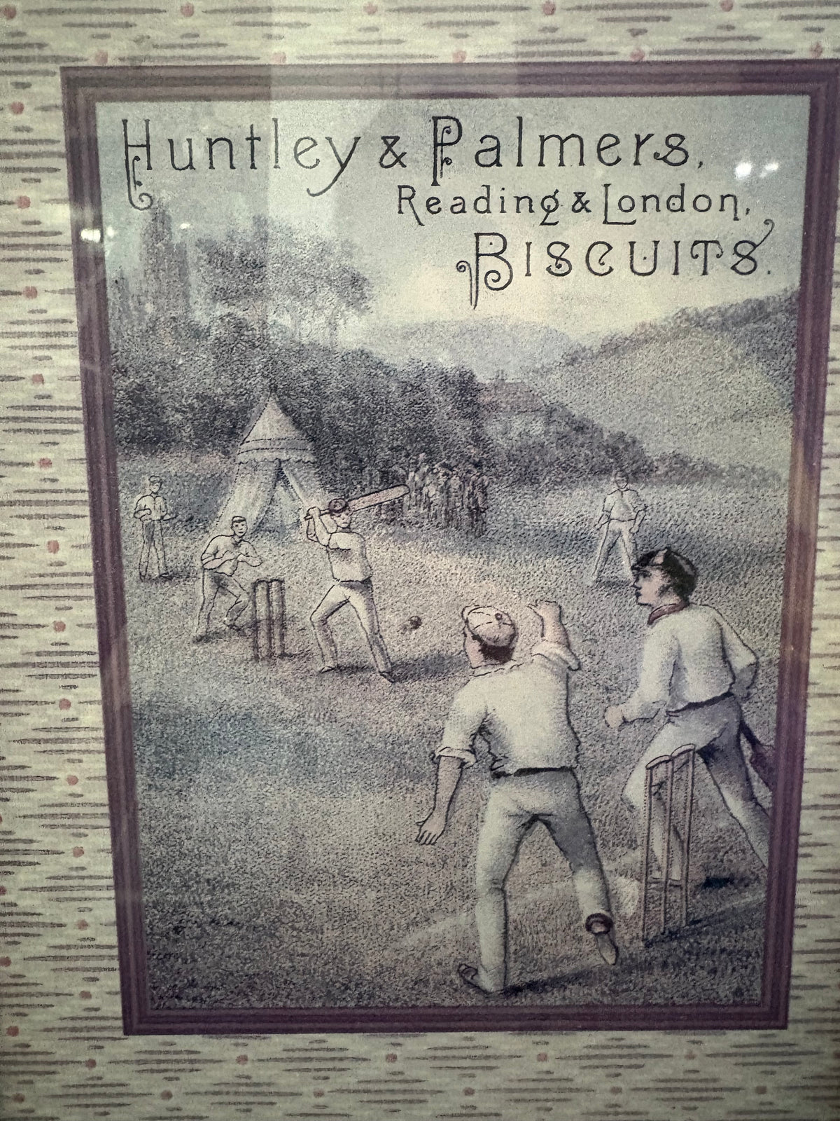 Close-up of the Huntley and Palmers biscuit advertisement showing a cricket match.