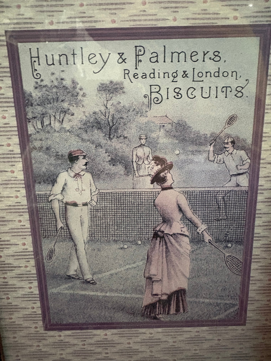 Close-up of the Huntley and Palmers biscuit advertisement showing a mixed doubles tennis game.