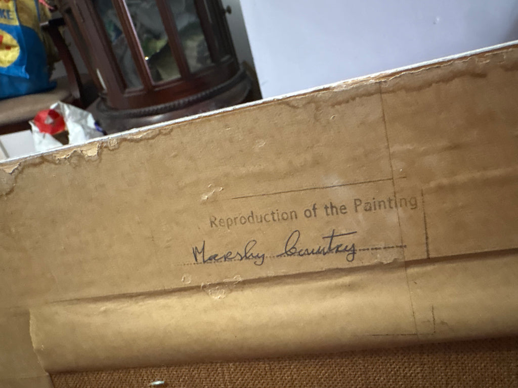 Reverse of the framed landscape showing a label reading Reproduction of the Painting.