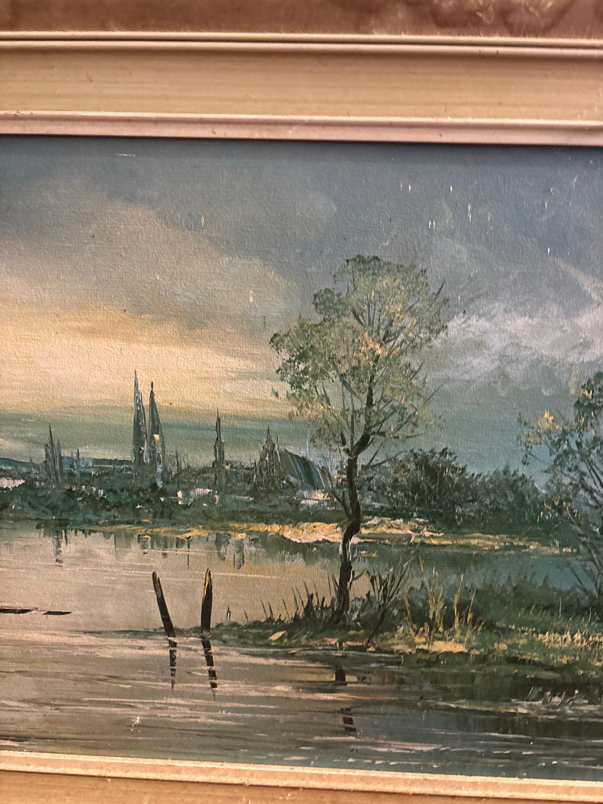 Central landscape detail showing a riverside tree, reflected light and distant church spires.