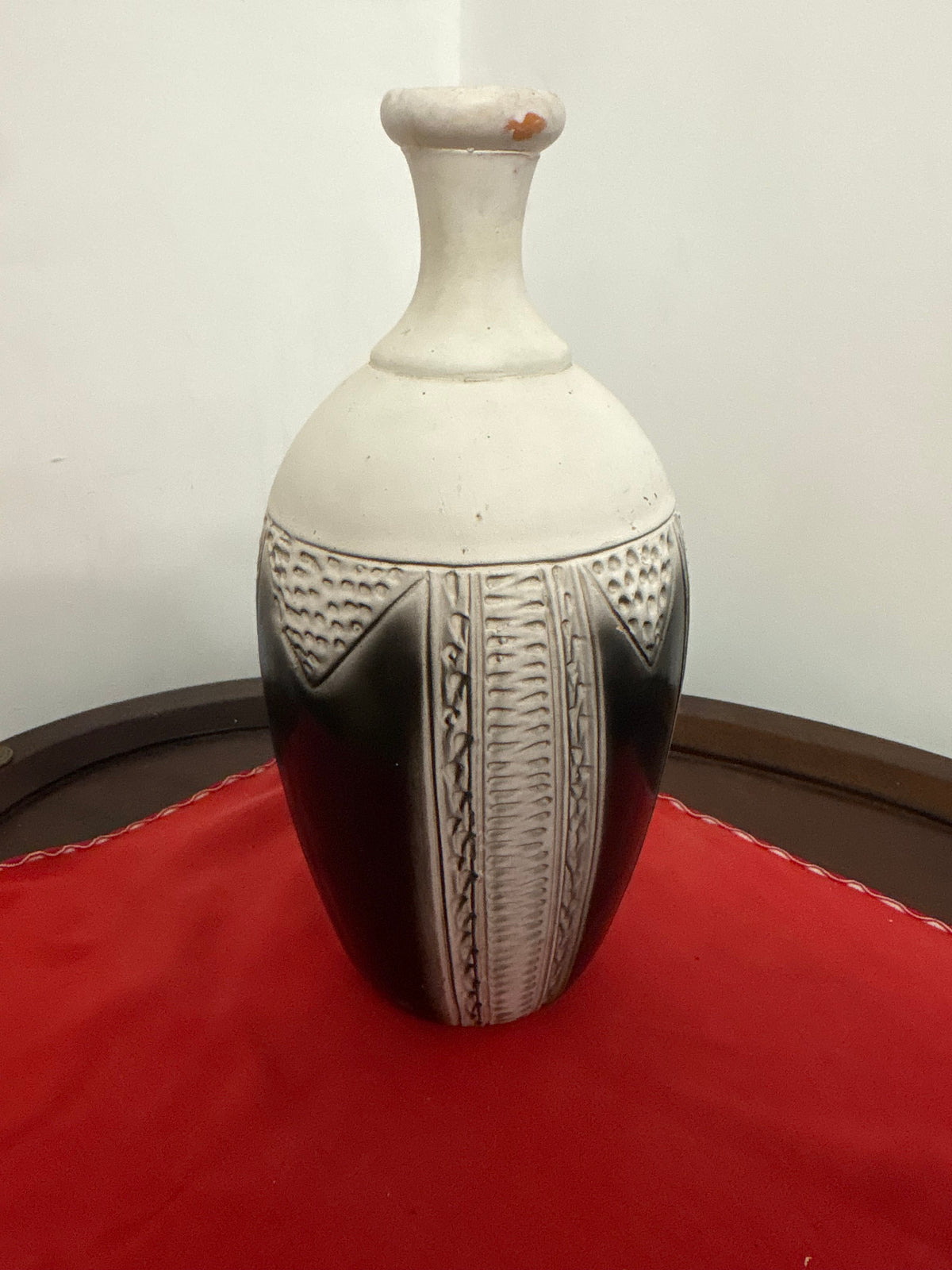 Cream-and-dark bottle-shaped vase with narrow neck and textured geometric panels