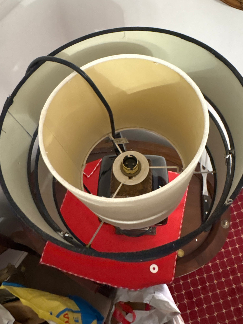 Top view inside the black banded lampshade showing the cream inner shade and bulb holder
