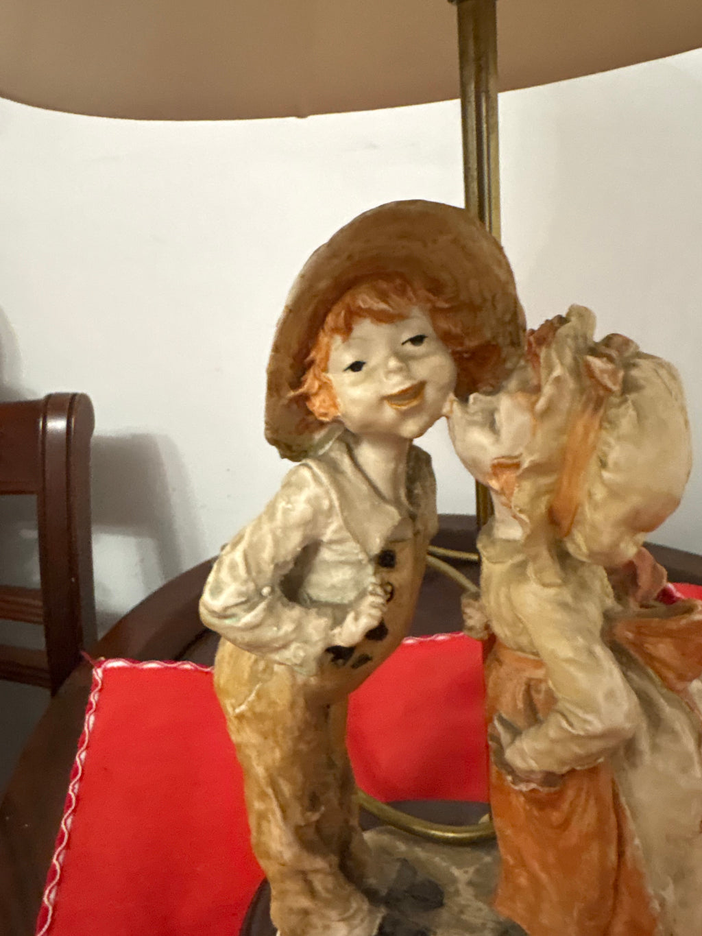 Close-up of the boy in a broad-brimmed hat and girl kissing on the Shy Kiss lamp