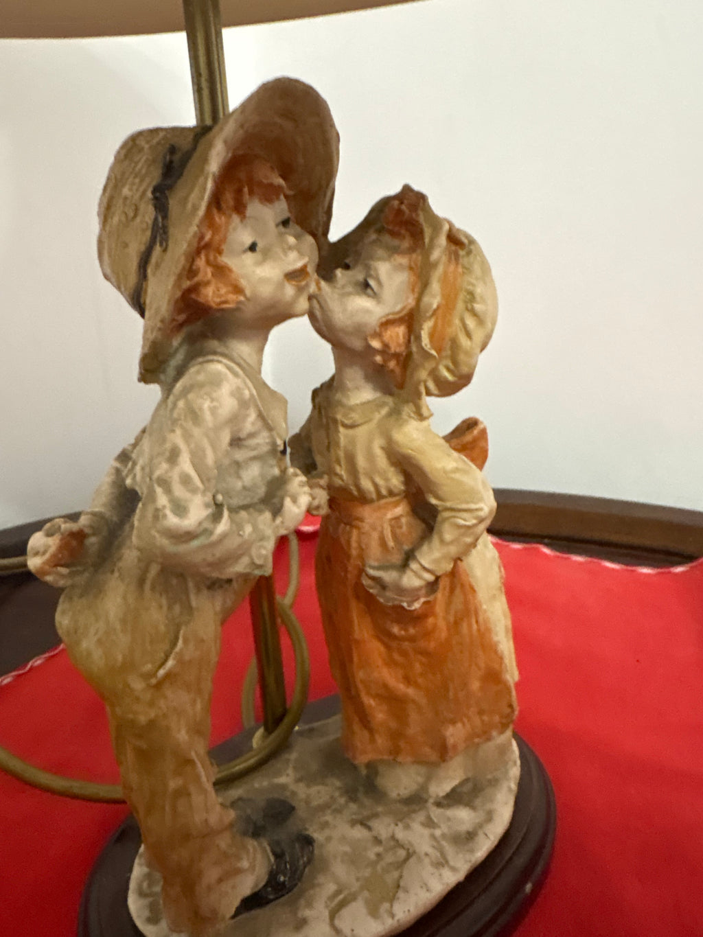 Front detail of the kissing children figurines on the oval table lamp base