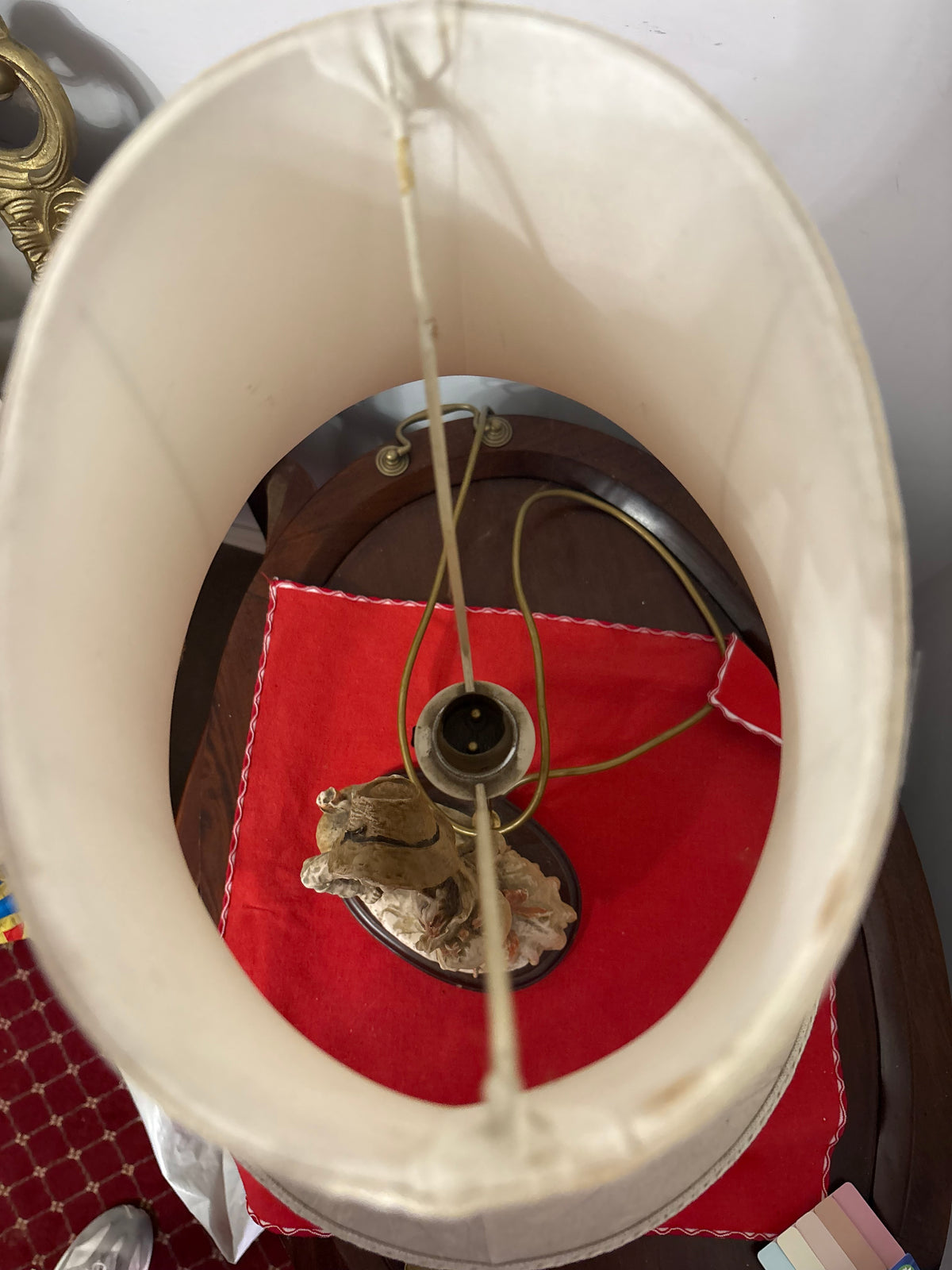 Wider top view of the cream oval lampshade with its lining, support arms and central bulb holder