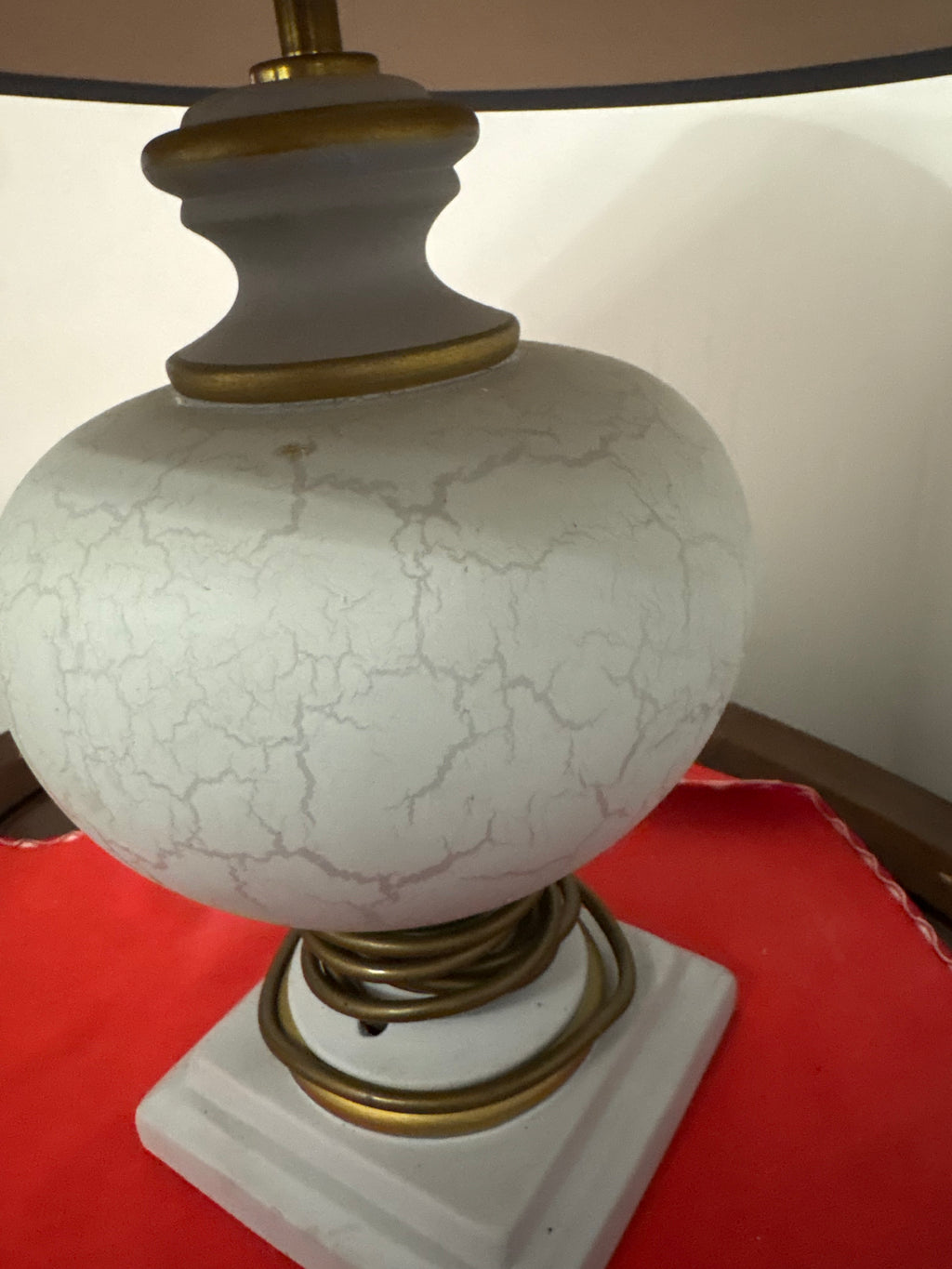 Angled close-up of crackle-glaze lamp showing the shaped neck, round body and gold-coloured trim