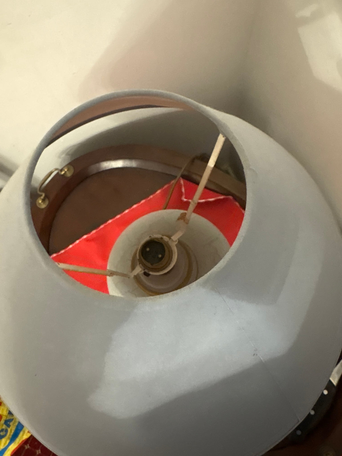 Top view inside the light blue lampshade showing its support frame and bulb holder