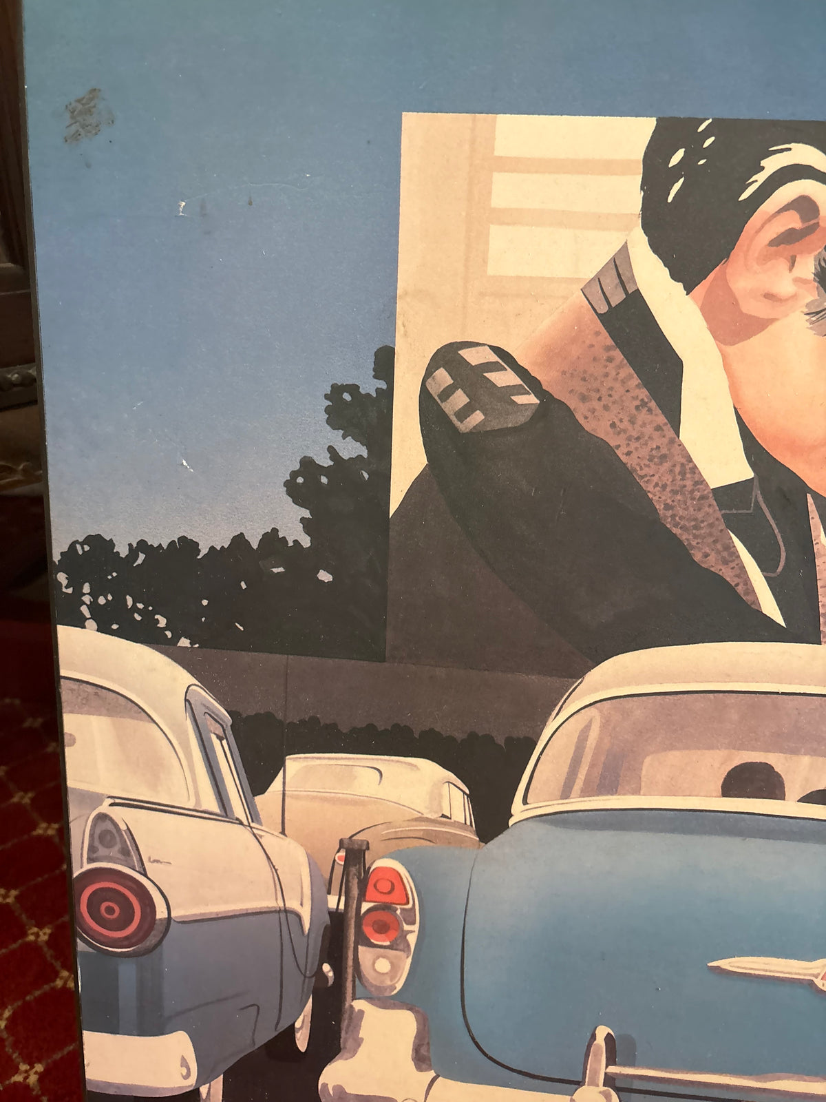Left-side drive-in print detail showing parked classic cars and part of the man on the cinema screen.
