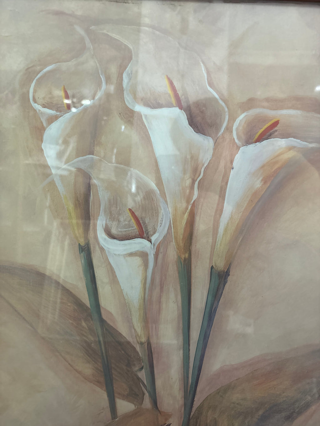Close-up of white calla lily blooms with warm-toned centres against a soft beige background.