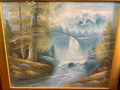 Framed mountain landscape with a cascading waterfall, snow-capped peaks and golden woodland beside a river.