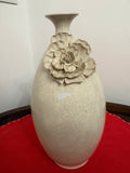 Off-white ceramic vase with narrow flared neck, crackled surface and large raised flower