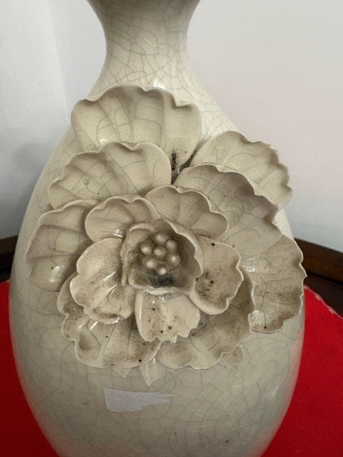 Close-up of layered ceramic flower petals and crackled glaze on the off-white vase