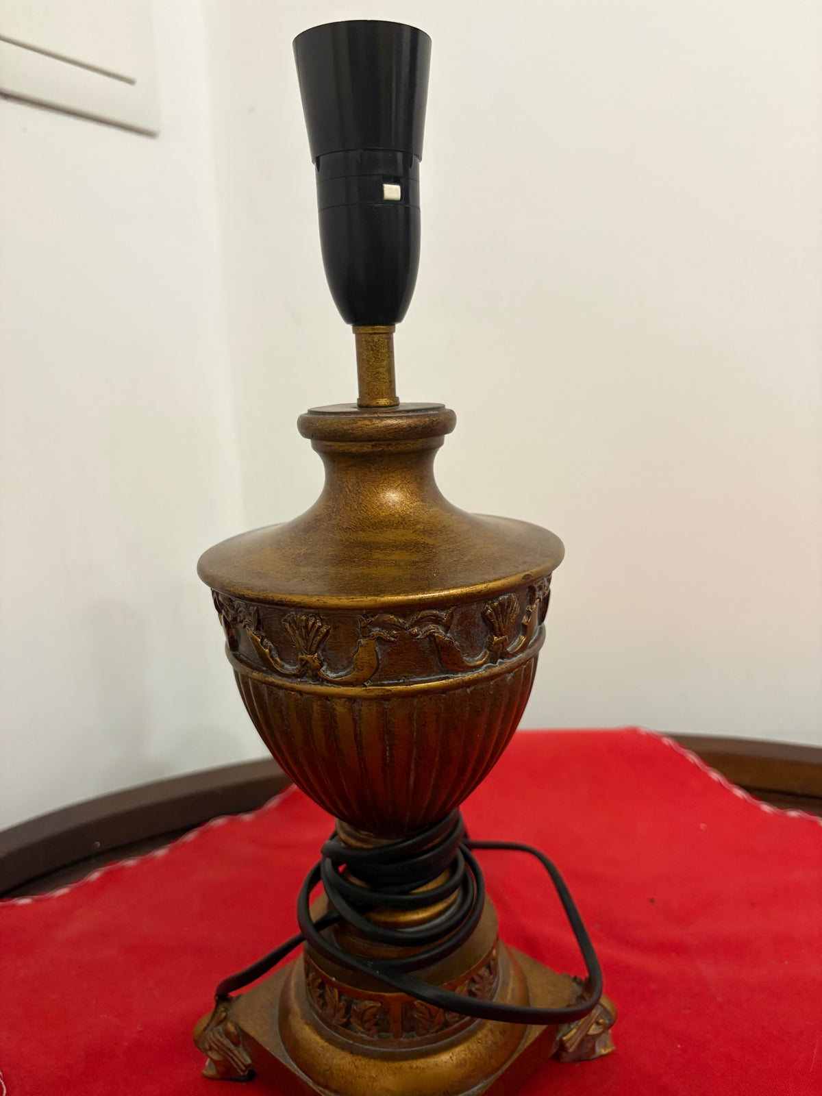 Brass urn lamp viewed from another angle, showing fluted body and square footed base