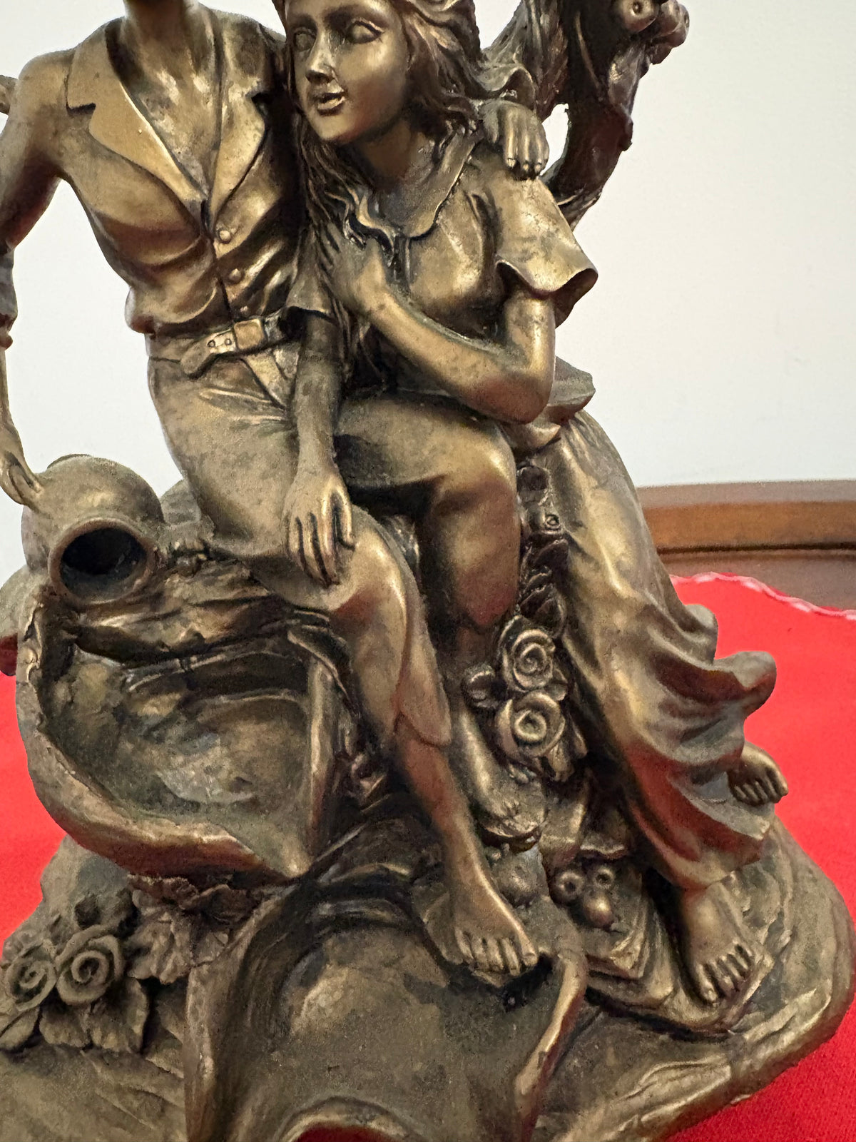 Detail of the seated couple’s clothing, bare feet and flower-decorated base beside the cascading bowls