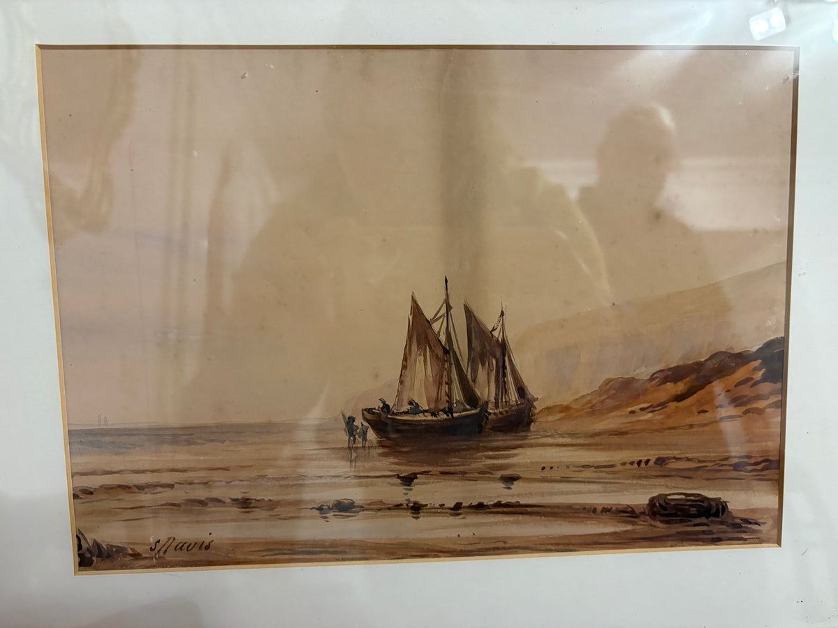Maritime watercolour showing two sailing boats on a sandy shore within a cream mount.